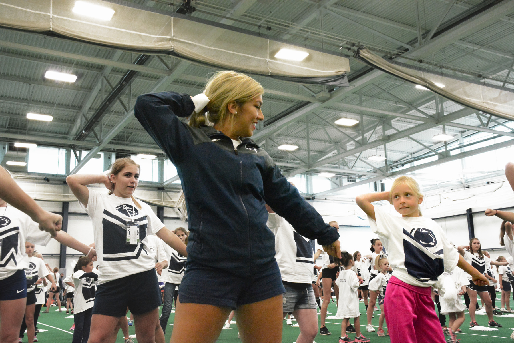 Penn State junior and varsity cheerleader Ally Lamanna teaches a routine to local youth cheerleaders before Penn State's first home football game vs. Buffalo on September 12, 2015 in the Multi-Sport Facility on the University Park campus.  The youth cheerleaders joined the varsity squad on the football field at halftime to perform the routine. Photo by Ally Ayton. 
