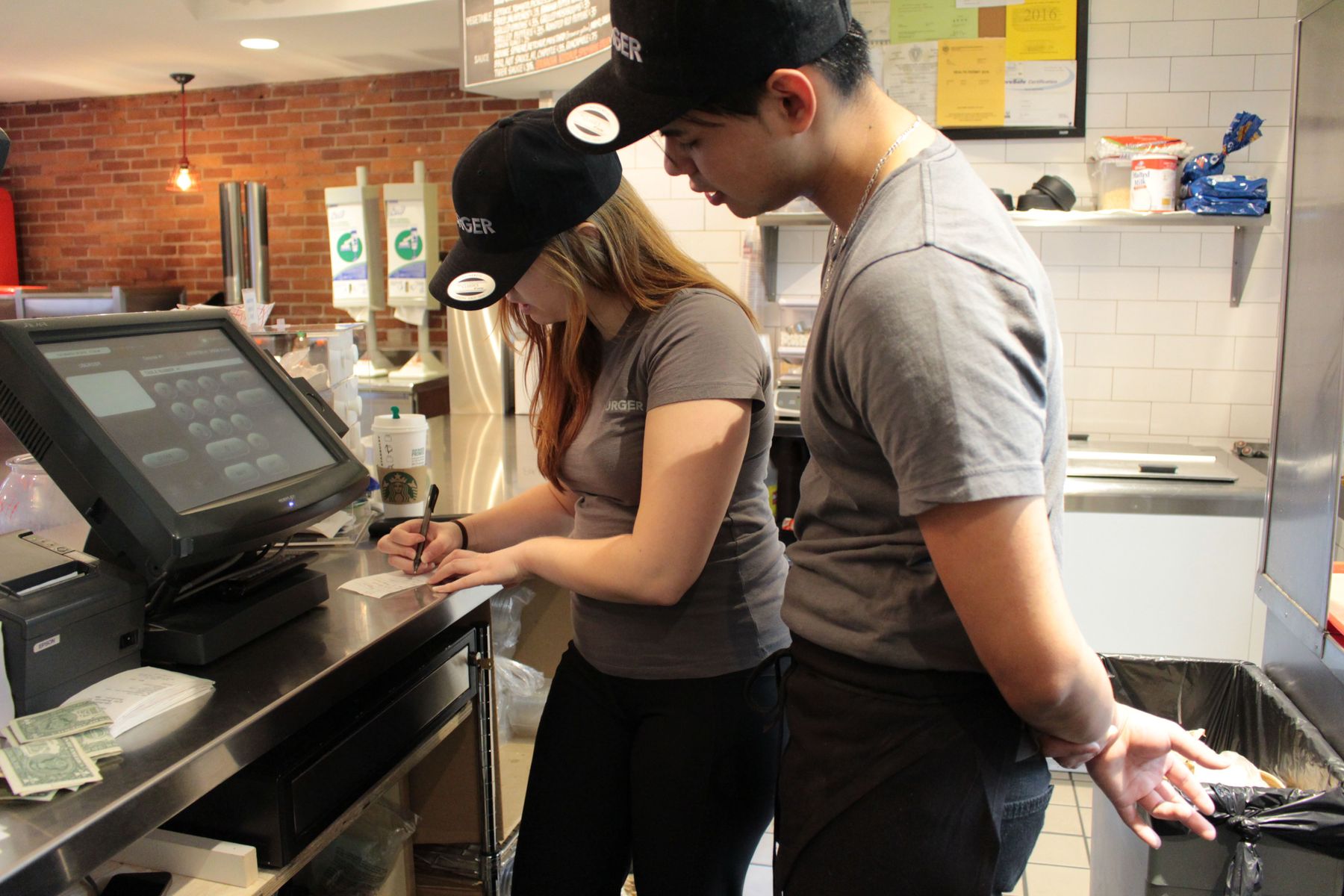 Gustavow stands with Megan as she takes down coffee orders. Megan routinely buys everyone coffee to get them through their double shifts. 
